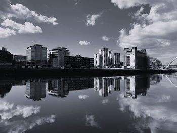 Reflection of buildings in lake against sky