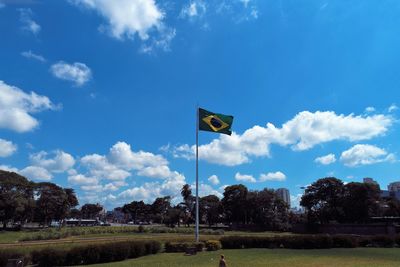 Road sign on field against sky