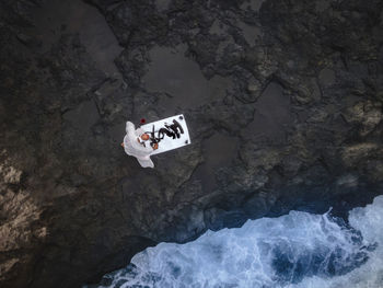 Monk doing calligraphy sitting on rock by sea