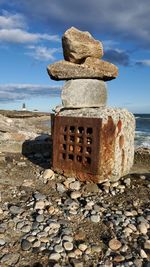 Stack of stones on beach against sky