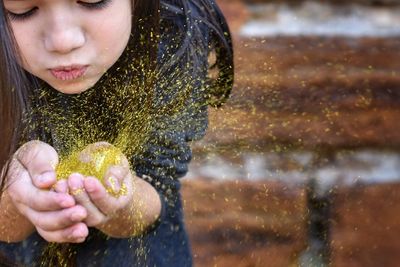 Girl blowing confetti outdoors