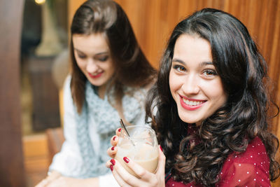 Portrait of a smiling young woman drinking glass