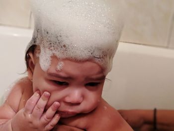 Close-up of cute baby boy bathing in bathtub