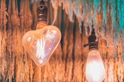 Close-up of light bulb hanging from ceiling