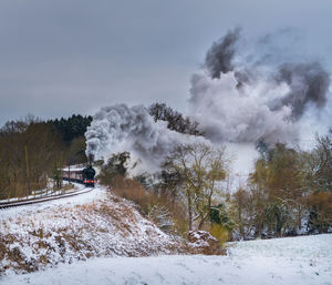 High angle view of steam train moving amidst landscape against sky