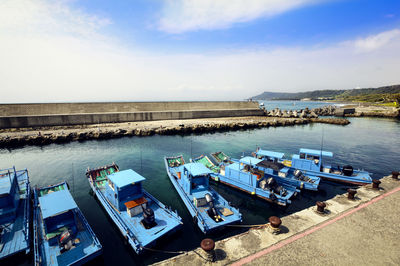 High angle view of boats moored at harbor against sky