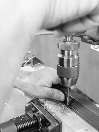 Cropped image of worker working on machinery in factory