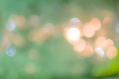 Defocused image of illuminated lights against sky