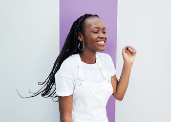 Portrait of young woman standing against white background