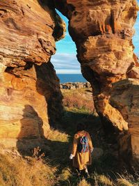 Rear view of woman standing on rock