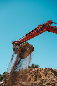 Low angle view of rusty metallic structure against clear blue sky