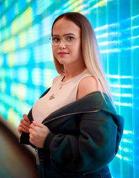 Portrait of young woman standing in city