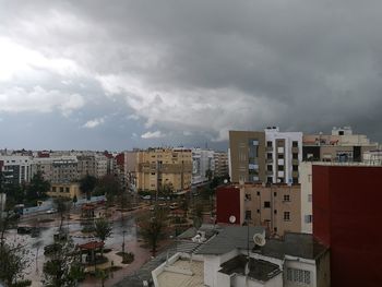 View of cityscape against cloudy sky