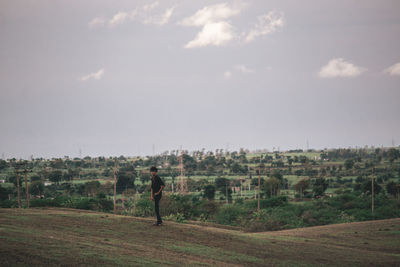 Man standing on field against sky