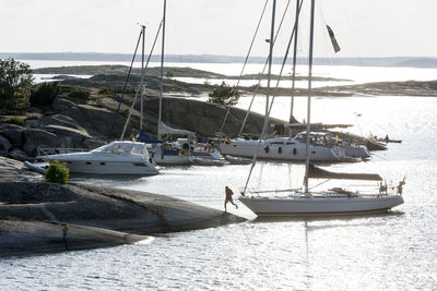 Yachts moored at rocky coast