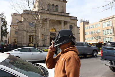 Rear view of woman standing on street in city