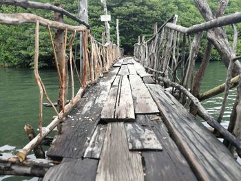 Empty wooden footbridge along lake