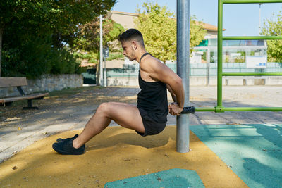 Side view of shirtless young man in swimming pool