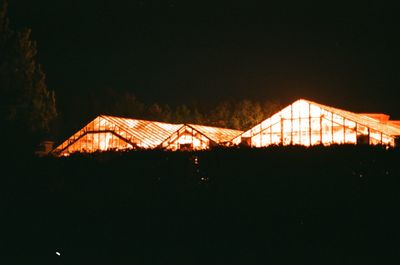 Illuminated house against sky at night