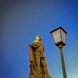 Low angle view of statue against blue sky