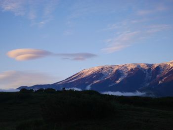 Scenic view of field and mountain against sky