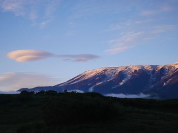 Scenic view of field and mountain against sky