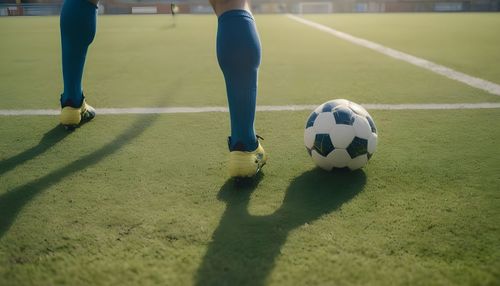 Low section of man playing soccer on field