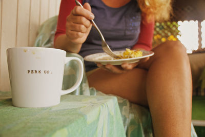 Midsection view of woman eating breakfast