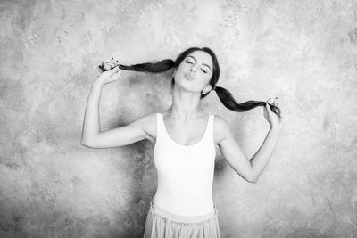 Full length of woman standing against wall