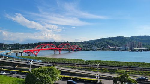 Bridge over river in city against sky