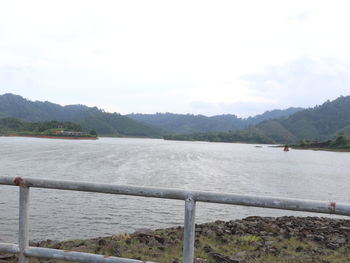 Scenic view of river and mountains against sky