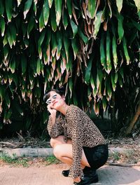 Side view of woman in tiger print blouse and sunglasses sitting outdoors