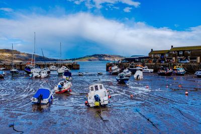 Boats in sea against cloudy sky