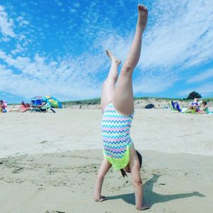 Full length of shirtless boy on beach against sky