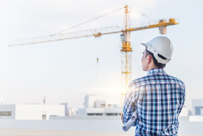 Man standing at construction site against sky