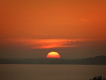 Scenic view of sea against romantic sky at sunset