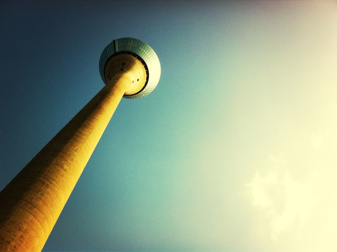 low angle view, tower, communications tower, tall - high, clear sky, built structure, architecture, street light, lighting equipment, sky, sphere, building exterior, communication, copy space, fernsehturm, television tower, technology, blue, tall, no people