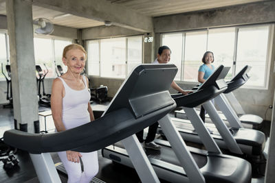 Man and women exercising on treadmill in gym