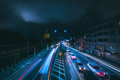 Light trails on road against sky at night