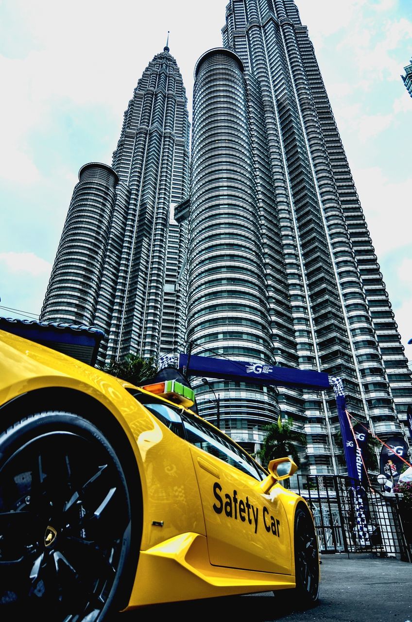 YELLOW CAR ON ROAD AGAINST SKY