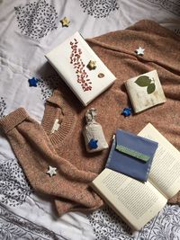 High angle view of presents on a sweater on bed