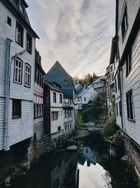 Canal amidst buildings in town against sky