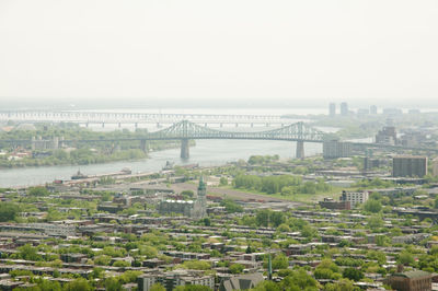 Bridge over river in city against sky