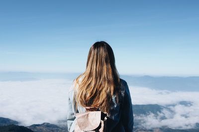 Woman standing by sea against sky