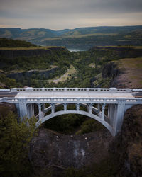 Bridge over mountain against sky