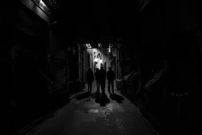 Rear view of people in illuminated tunnel