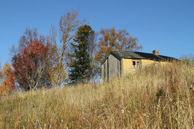 Abandoned house on field against clear sky