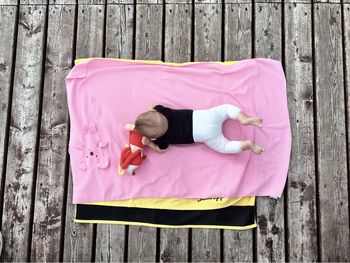 Directly above shot of baby playing with toy on pier