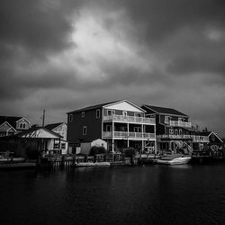 View of river by houses against sky