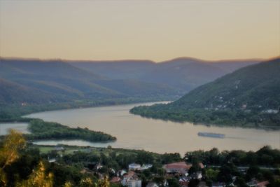 Scenic view of river by mountains against sky